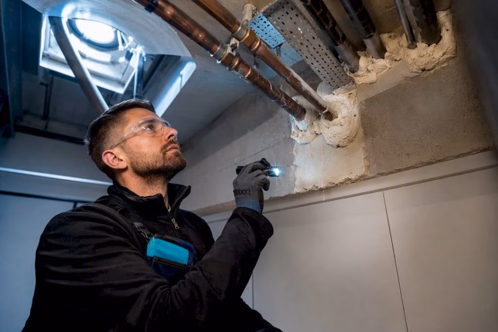 Surveyor inspecting fire stopping around service penetrations